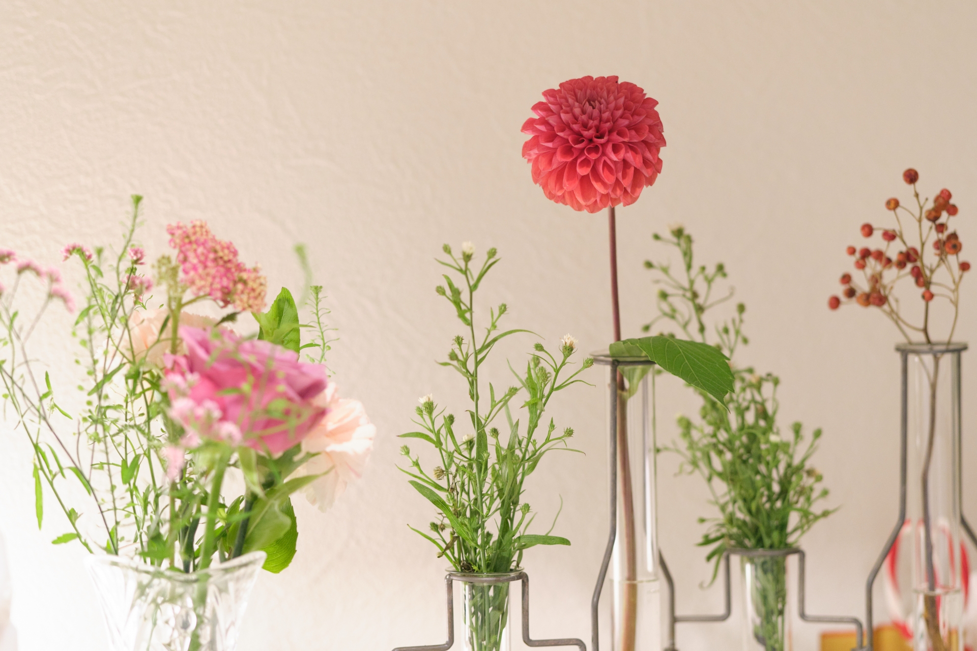 複数の花がそれぞれ花瓶に生けてある様子