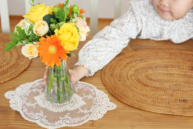 子供が花の花瓶を飾っている様子